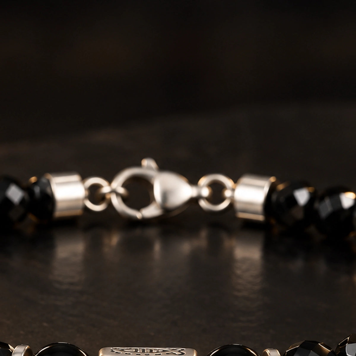 Alloy lobster clasp and connector structure on black obsidian bracelet