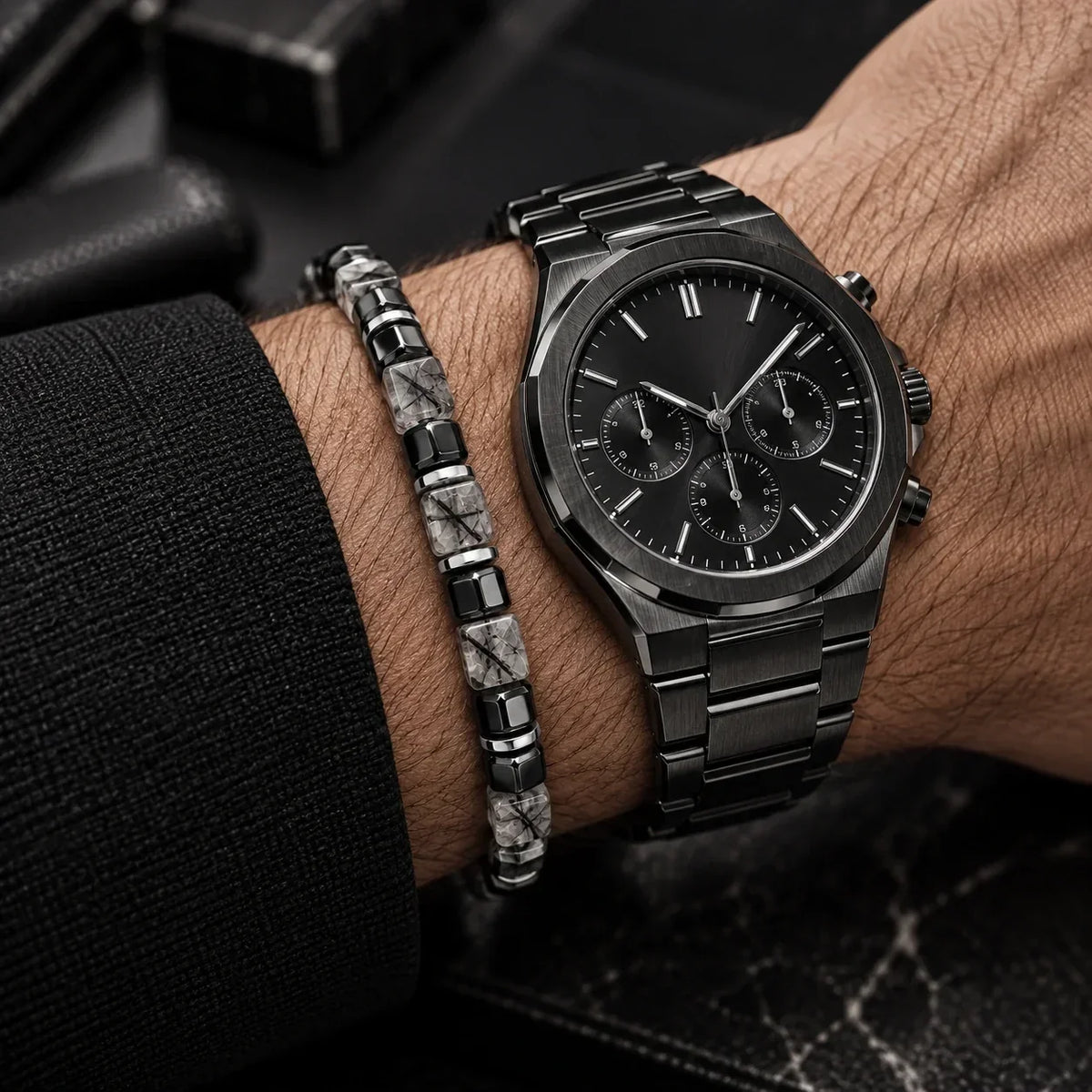 Black rutilated quartz bracelet styled beside a black watch