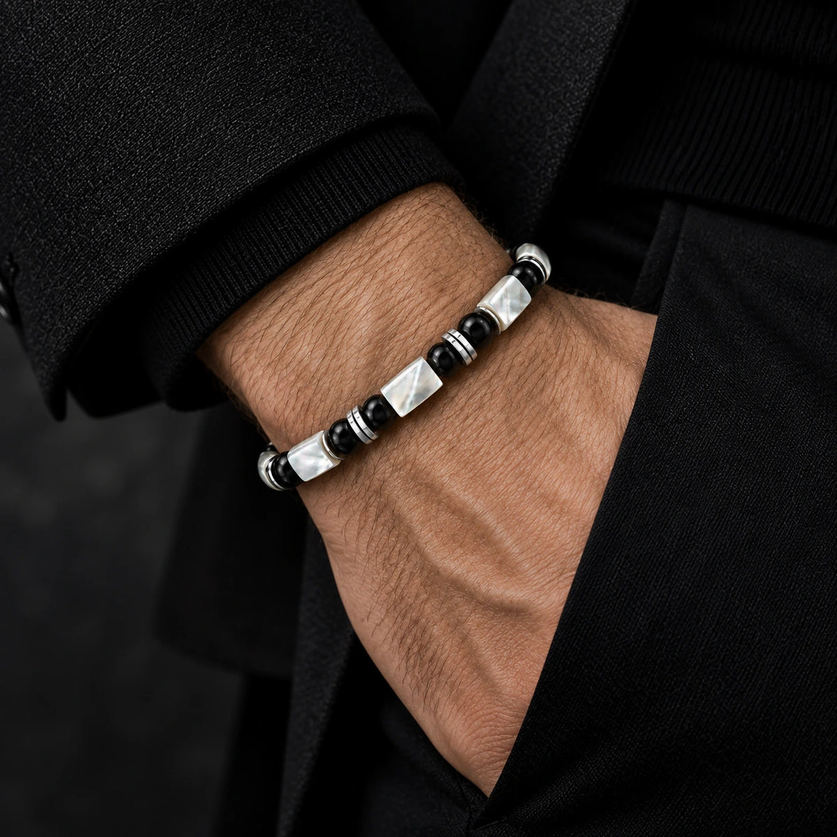Mother-of-pearl and obsidian bracelet worn on wrist