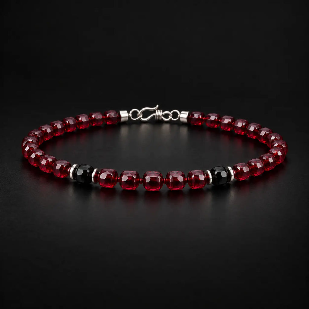 Natural garnet and black obsidian bracelet at a 45-degree angle showing faceted stone luster.