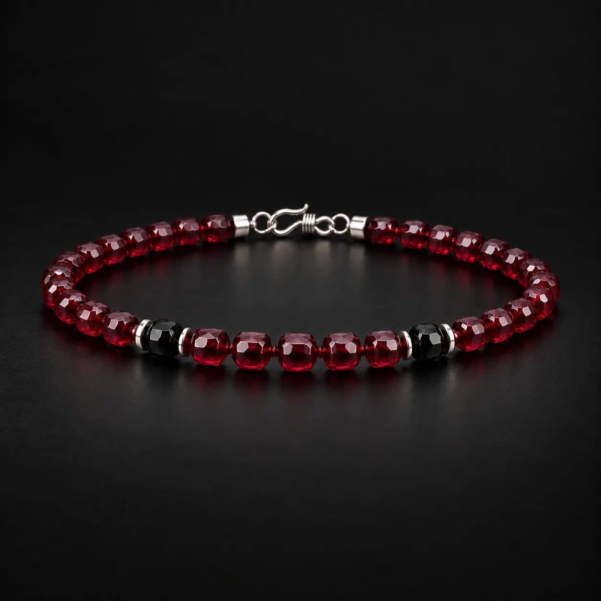 Natural garnet and black obsidian bracelet at a 45-degree angle showing faceted stone luster.