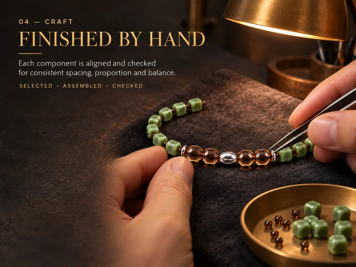 Hand alignment and inspection of the nephrite and smoky quartz bracelet.
