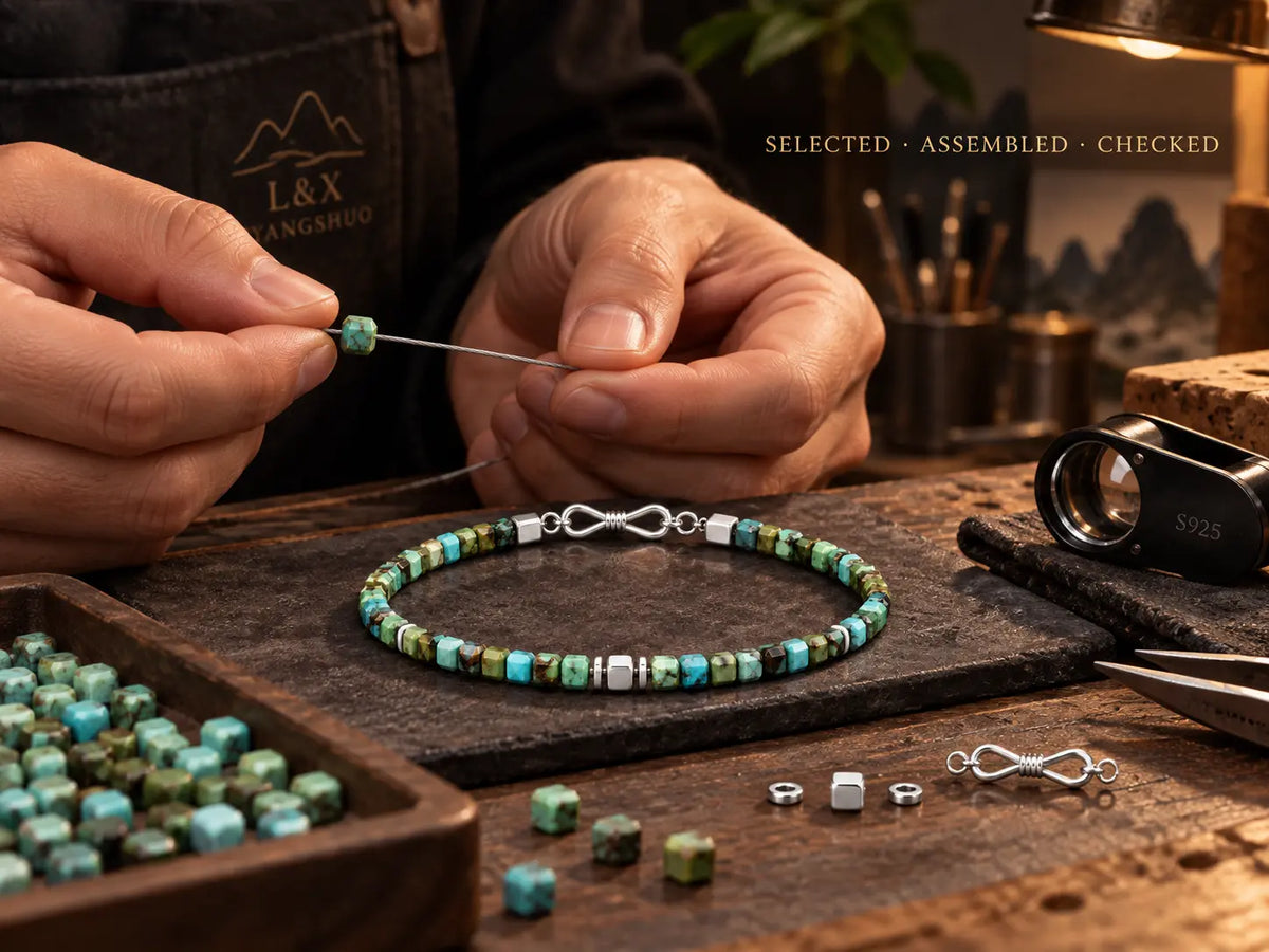 Artisan assembling selected turquoise cube beads by hand on jewelry steel cable.