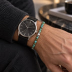 Natural turquoise cube bracelet with S925 silver center styled beside a black leather-strap wristwatch.